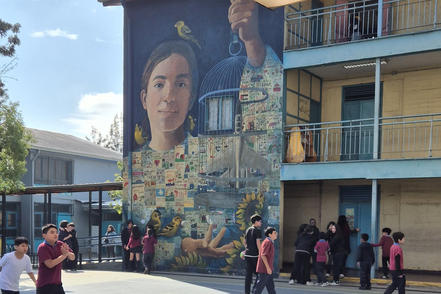 Patio del Centro Educacional Horacio Aravena, con el mural de una niña que sostiene una jaula abierta
